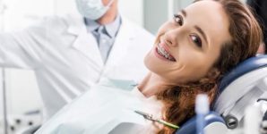 woman in braces during examination of teeth near dentist