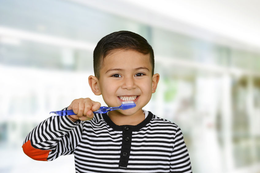 Young child brushing his teeth.