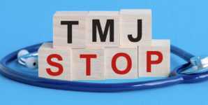 Wooden block with words TMJ Stop - with stethoscope on the table