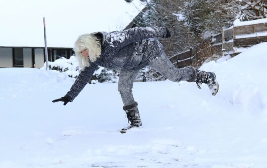 Photo of a woman almost slipping on the snow and ice.