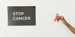 Advocate holding an Cancer Ribbon and sign that reads Stop Cancer.
